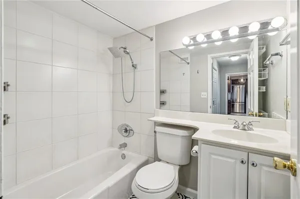 a bathroom with a sink a toilet a mirror a vanity and bathtub