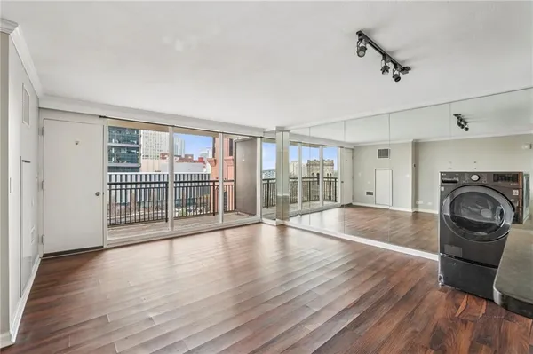 wooden floor in an empty room with a fireplace and a window