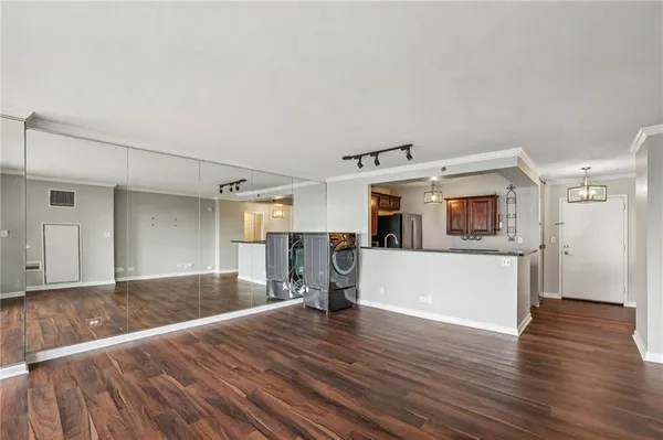 a view of a big room with wooden floor and windows