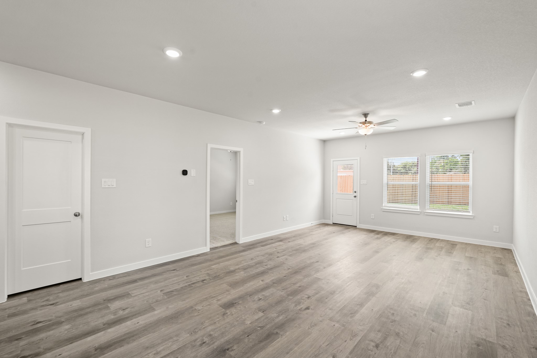 213 Spring Drive Hockley, TX 77447 - Photo 11 of 26 a view of an empty room with wooden floor and windows