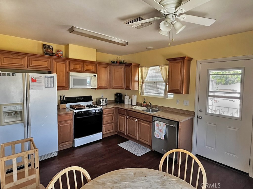 1205 Opal Way Mentone, CA 92359 - Photo 4 of 17 a kitchen with stainless steel appliances granite countertop a refrigerator a stove a sink dishwasher and wooden cabinets
