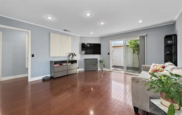a living room with furniture flat screen tv and wooden floor