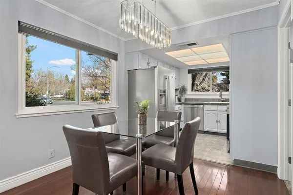 a dining room with furniture a chandelier and wooden floor