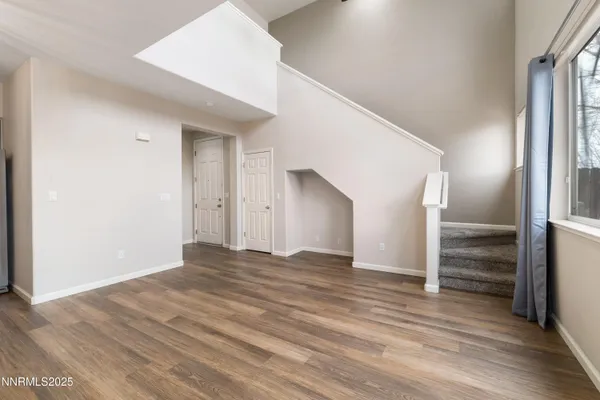 a view of empty room with wooden floor