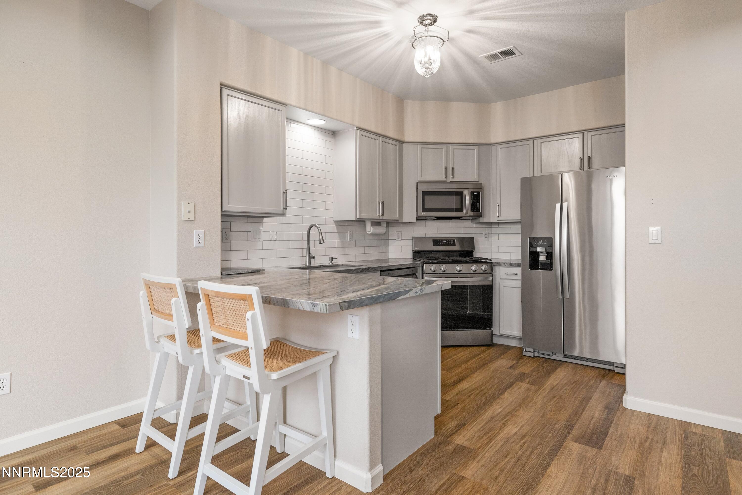 9294 Lone Wolf Circle Reno, NV 89506 - Photo 8 of 25 a kitchen with stainless steel appliances a microwave a stove and refrigerator