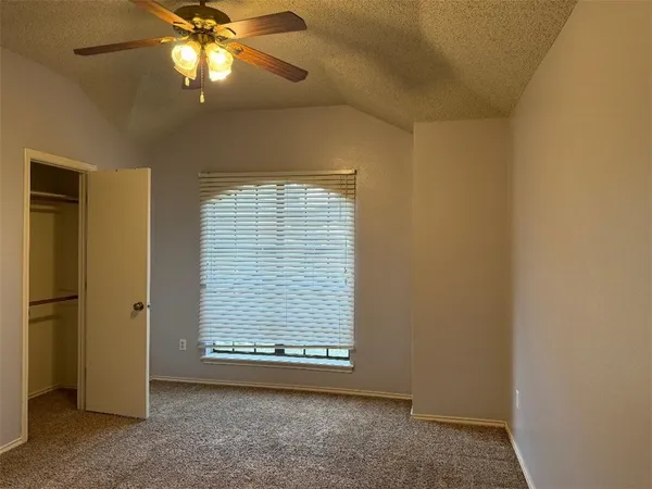 an empty room with windows and fan