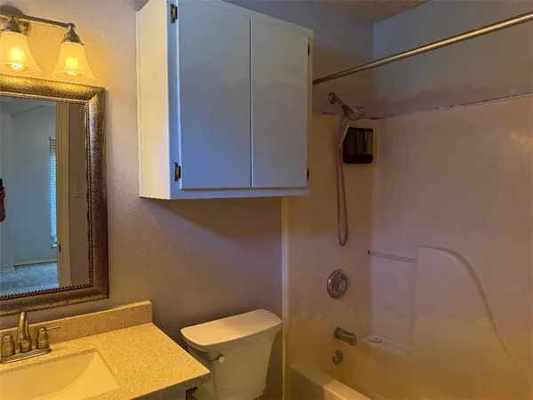 a bathroom with a tub a sink and a toilet