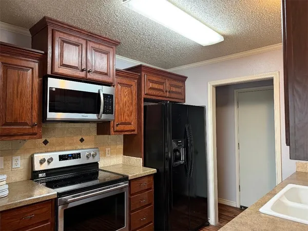 a kitchen with a refrigerator and a stove top oven