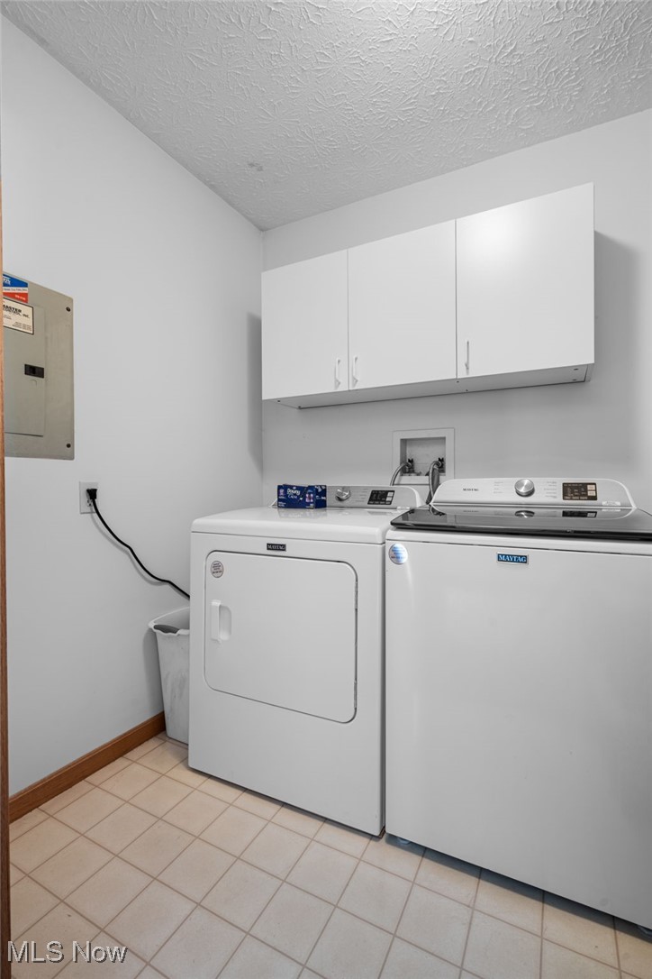 64 River Ridge Lane Munroe Falls, OH 44262 - Photo 17 of 25 Laundry area featuring electric panel, light tile patterned floors, separate washer and dryer, a textured ceiling, and cabinet space