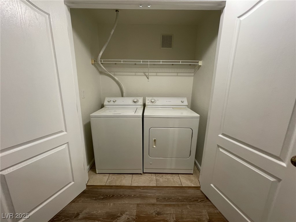 10217 King Henry Avenue, Unit 104 Las Vegas, NV 89144 - Photo 15 of 18 Laundry room featuring washer and clothes dryer and dark wood finished floors