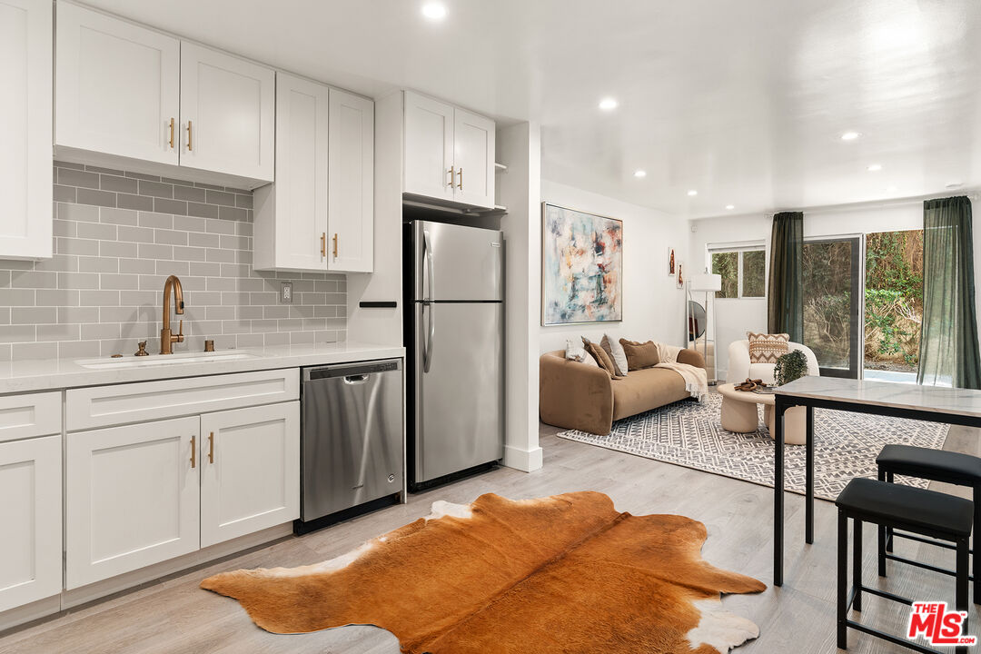 532 North Rossmore Avenue, Unit 107 Los Angeles, CA 90004 - Photo 3 of 12 a kitchen with a refrigerator and a sink