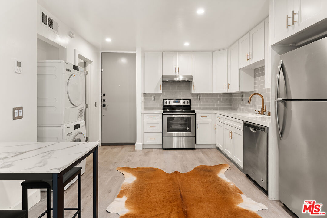 532 North Rossmore Avenue, Unit 107 Los Angeles, CA 90004 - Photo 4 of 12 a kitchen with stainless steel appliances granite countertop a refrigerator sink stove and refrigerator