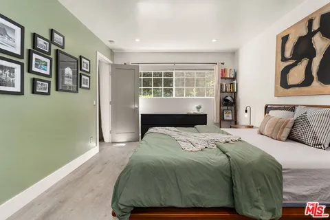 a bedroom with a bed and painting on the wall
