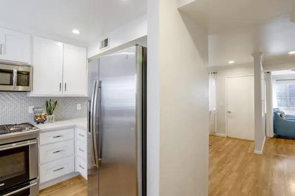 a kitchen with stainless steel appliances a refrigerator sink and microwave