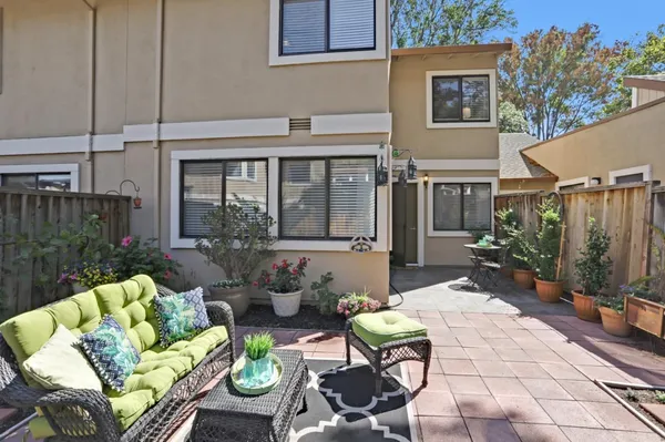 a view of a patio with couches table and chairs and potted plants