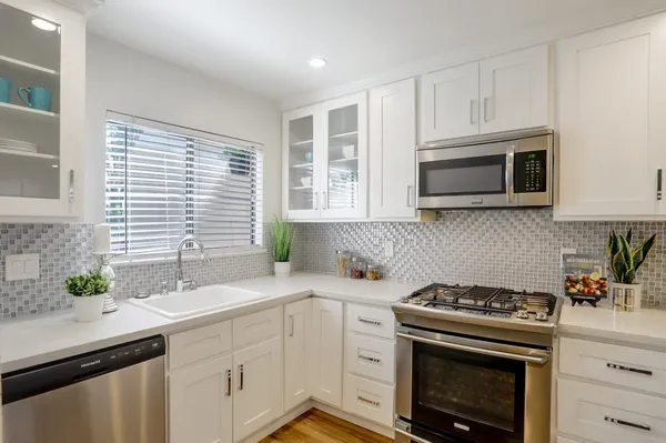 a kitchen with stainless steel appliances a stove a sink a microwave and cabinets