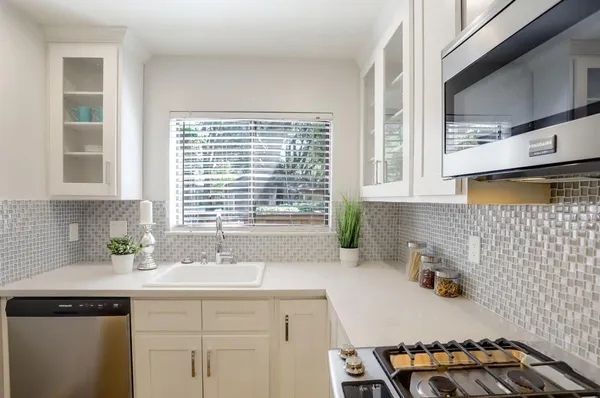 a kitchen with a sink a window and cabinets
