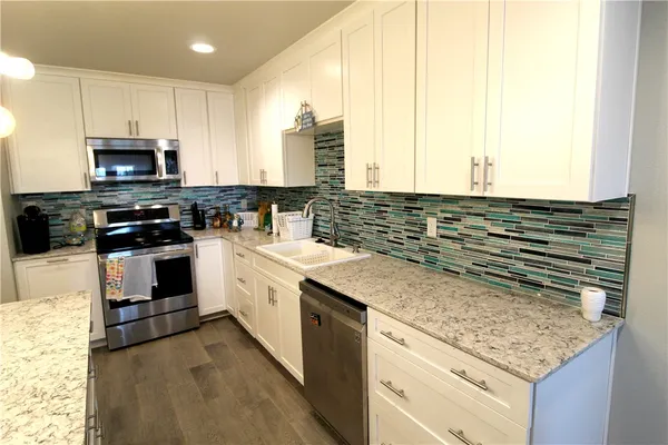 a spacious bathroom with a granite countertop sink a mirror and shower