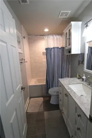 a bathroom with a granite countertop sink a mirror and shower