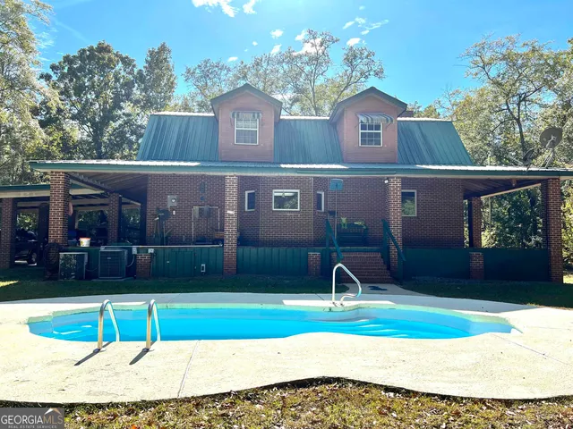 a view of a house with large trees and wooden fence