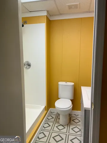 a bathroom with a toilet a sink and mirror