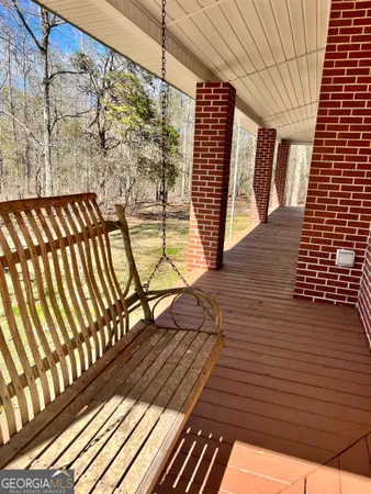 an empty room with wooden floor cabinet and windows