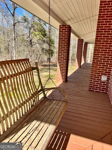 an empty room with wooden floor cabinet and windows