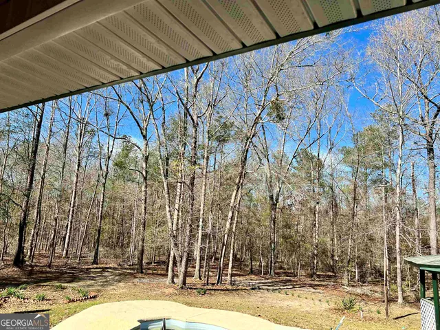 a kitchen with stainless steel appliances granite countertop a stove top oven a sink a dining table and chairs with wooden floor