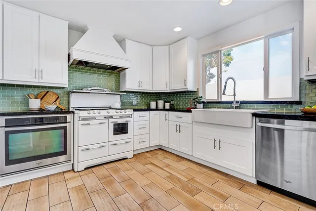 a kitchen with white cabinets appliances and a sink
