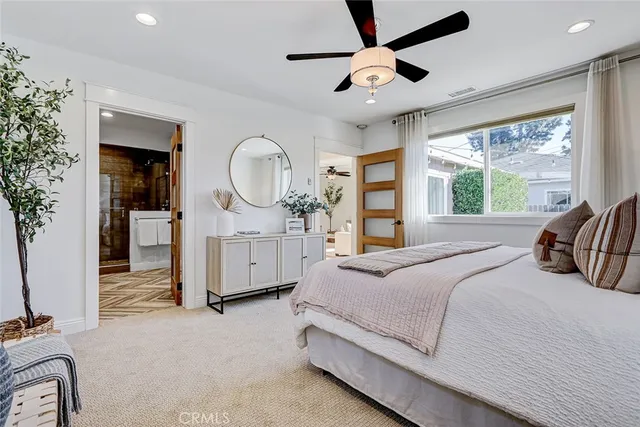 a bedroom with a large bed and a chandelier