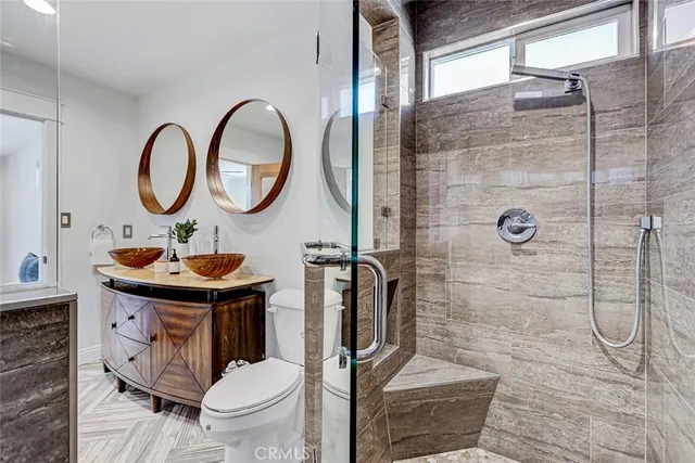 a bathroom with a sink toilet mirror and shower