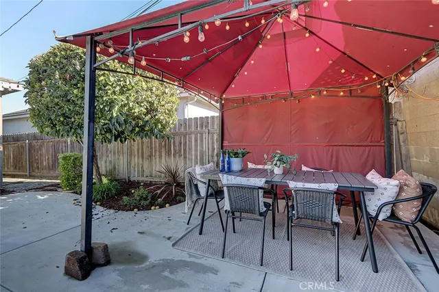 a patio with a table and chairs under an umbrella