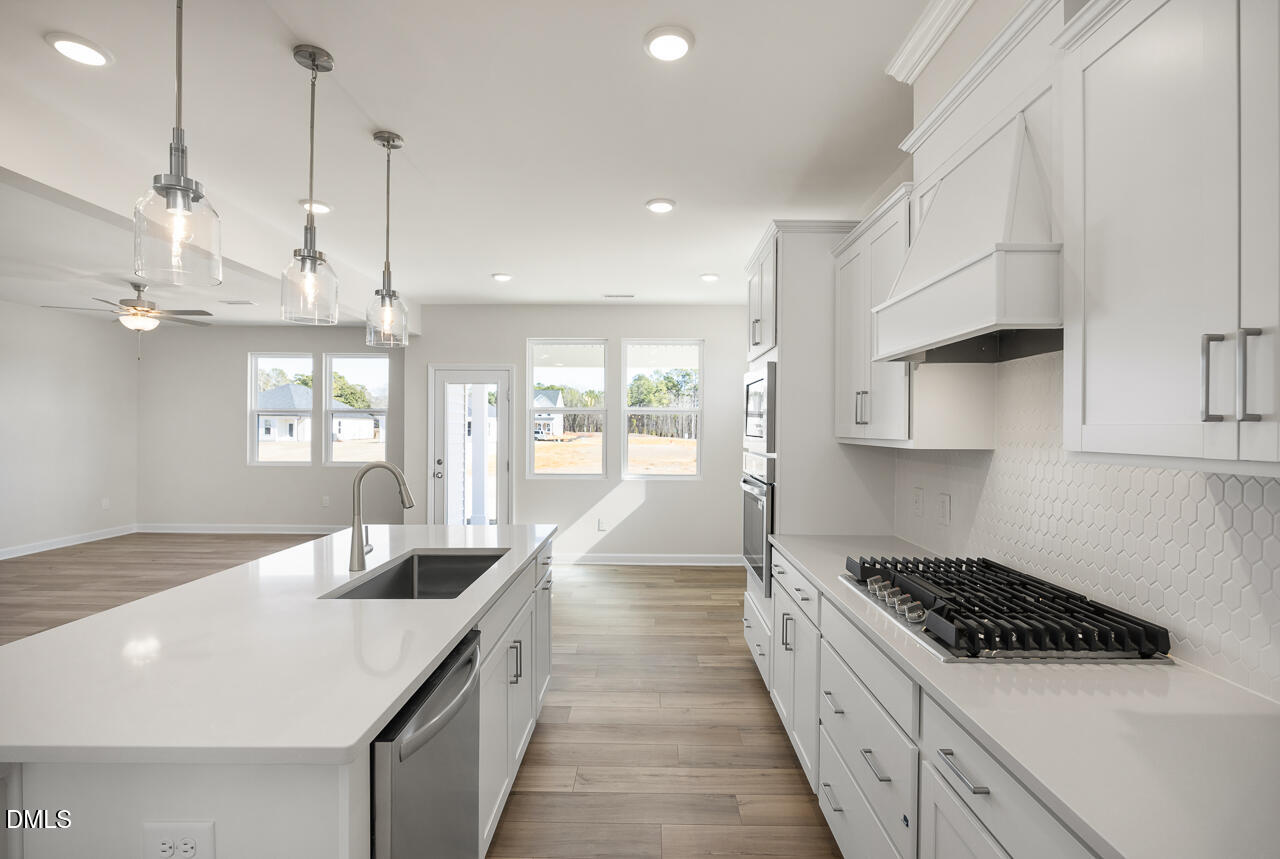 233 Tenure Lane Lillington, NC 27546 - Photo 11 of 30 a kitchen with stainless steel appliances granite countertop a sink a stove and a wooden floors
