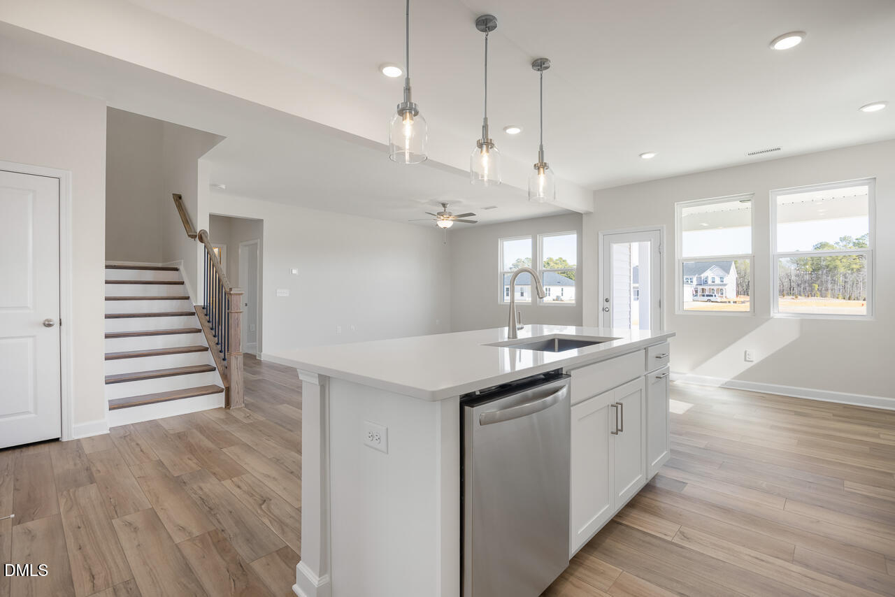 233 Tenure Lane Lillington, NC 27546 - Photo 12 of 30 a kitchen with stainless steel appliances granite countertop a sink a stove and a wooden floors