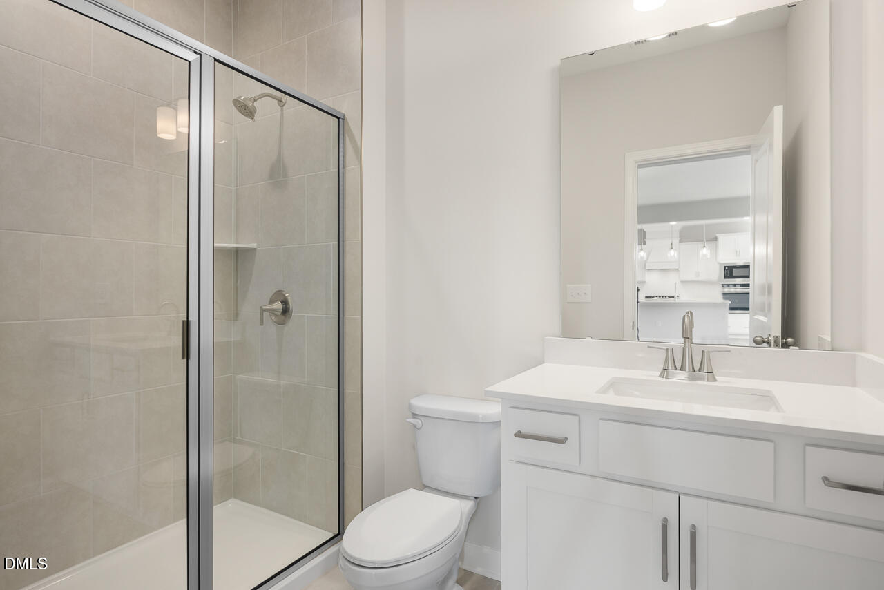 233 Tenure Lane Lillington, NC 27546 - Photo 13 of 30 a bathroom with a sink a toilet and shower