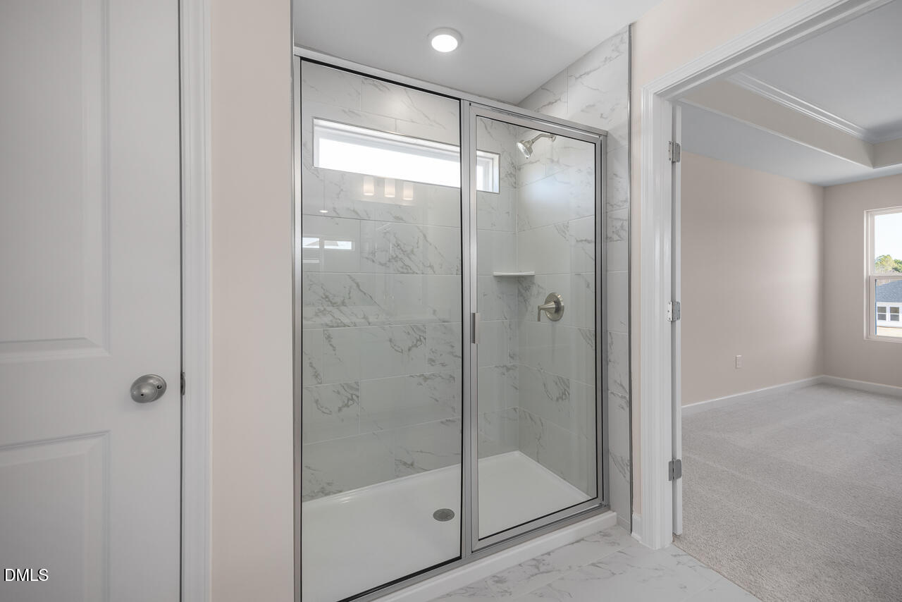 233 Tenure Lane Lillington, NC 27546 - Photo 21 of 30 a bathroom with a glass shower door
