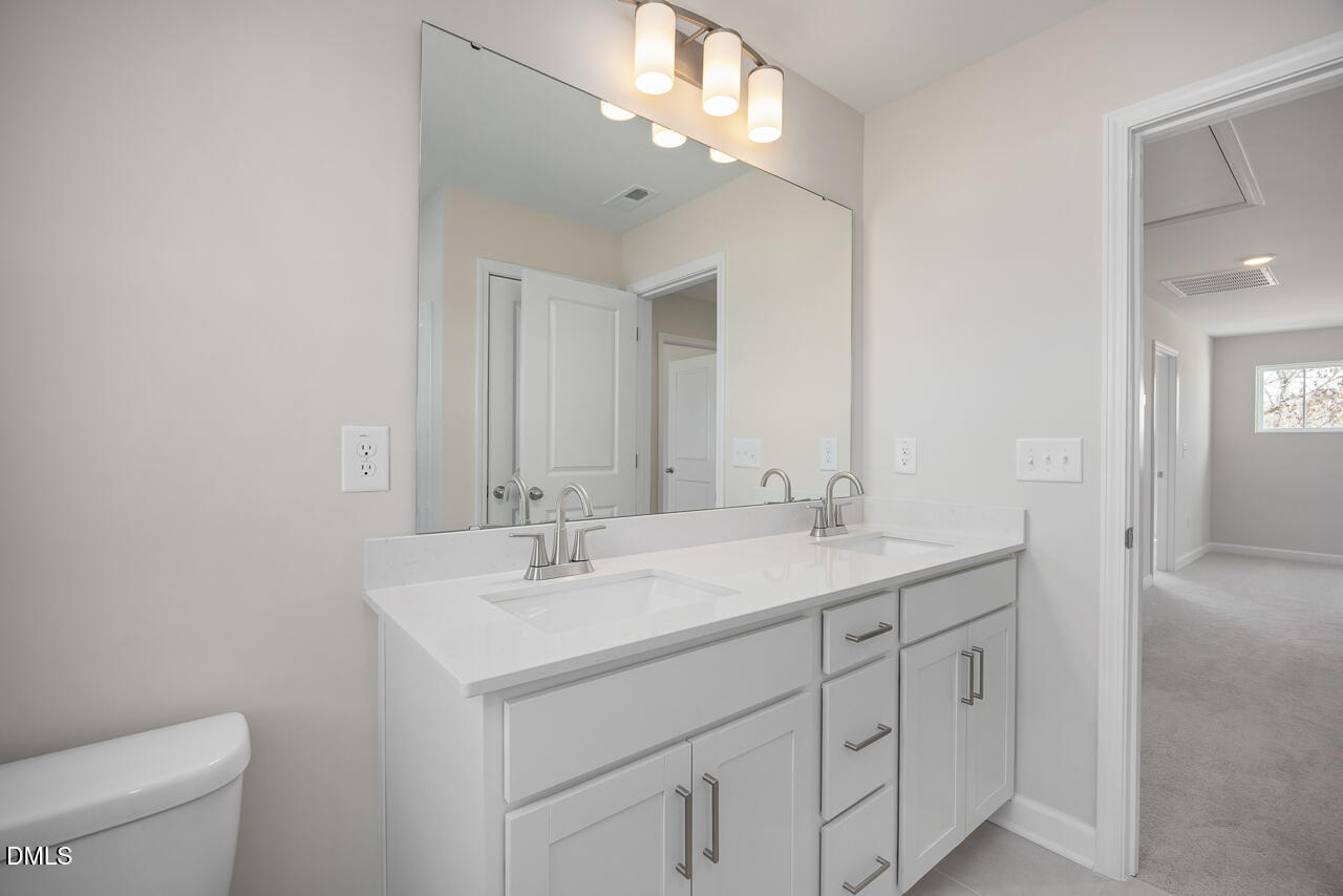 233 Tenure Lane Lillington, NC 27546 - Photo 26 of 30 a bathroom with a sink a toilet and a mirror