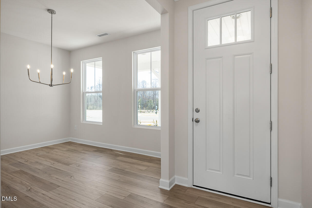 233 Tenure Lane Lillington, NC 27546 - Photo 2 of 30 a view of an empty room with wooden floor and a window