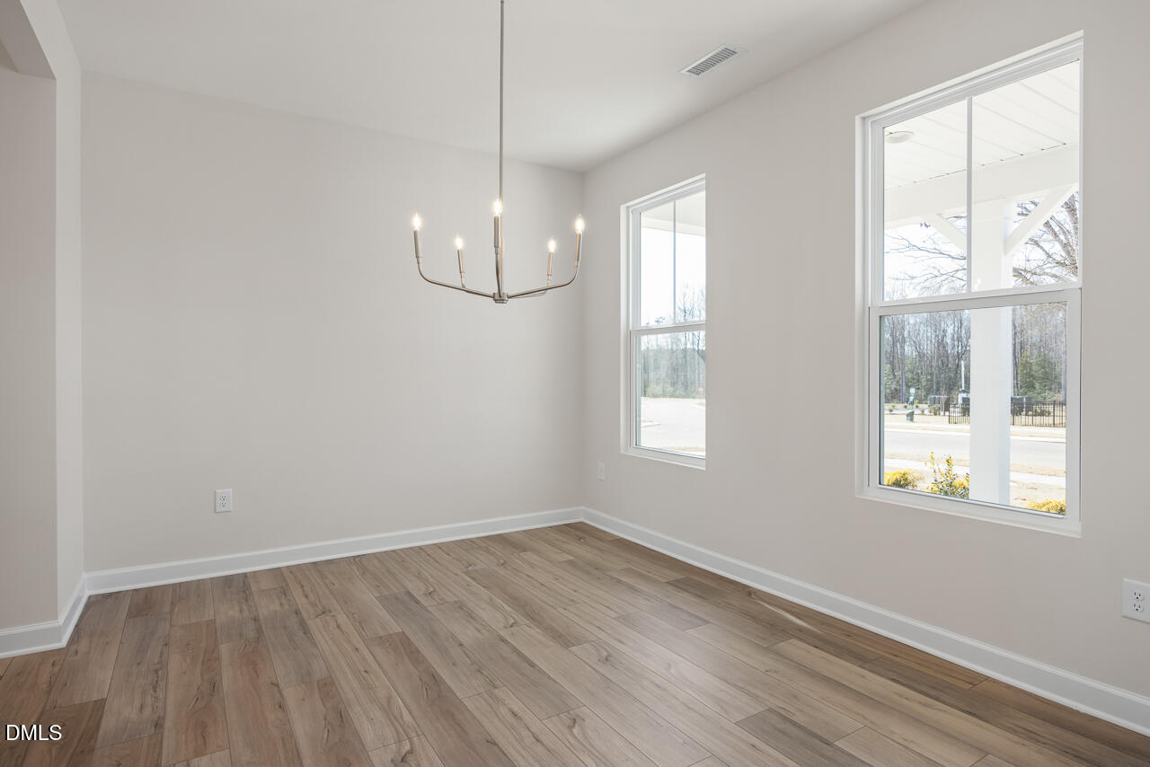 233 Tenure Lane Lillington, NC 27546 - Photo 3 of 30 an empty room with wooden floor and windows
