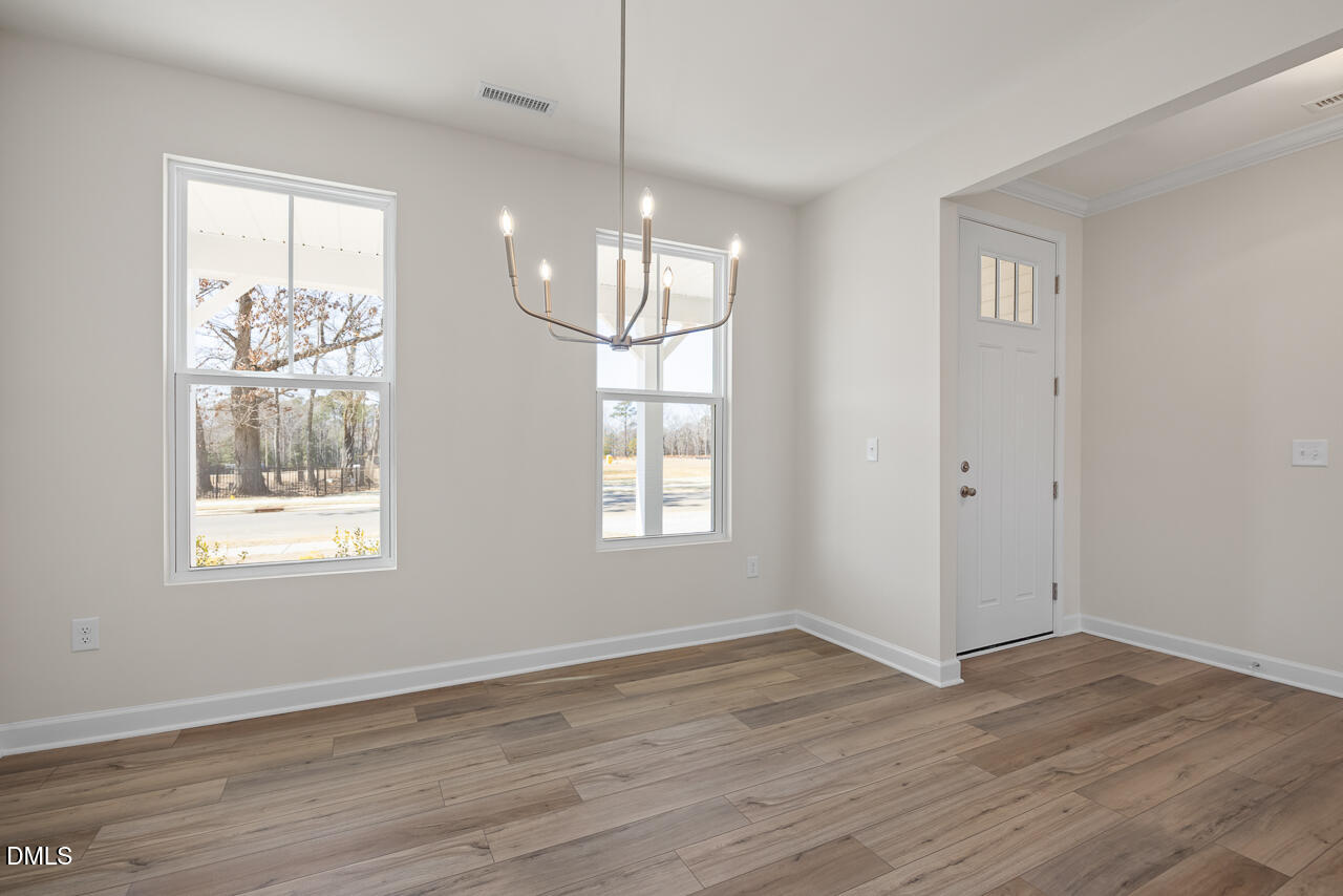 233 Tenure Lane Lillington, NC 27546 - Photo 4 of 30 an empty room with wooden floor and windows