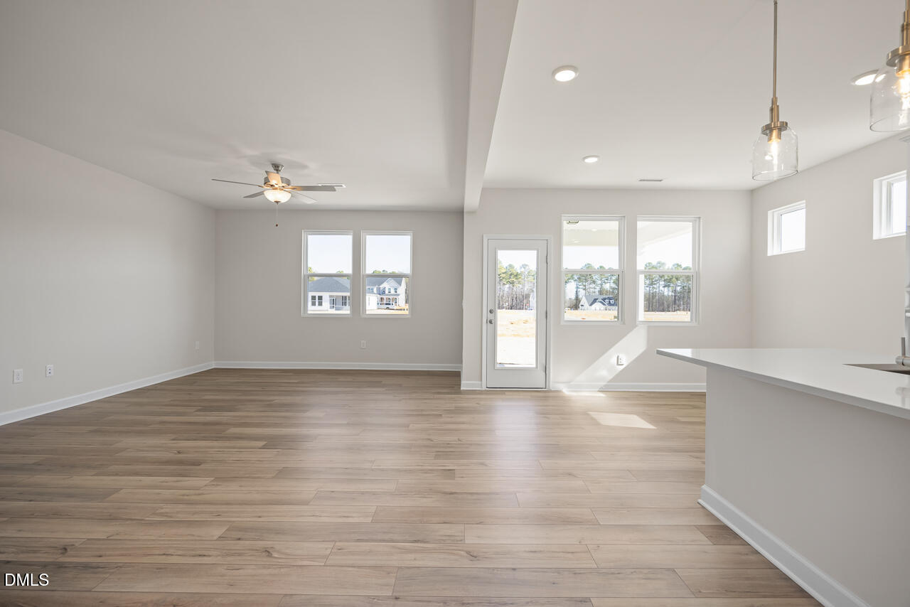 233 Tenure Lane Lillington, NC 27546 - Photo 5 of 30 a view of an empty room with a window and wooden floor