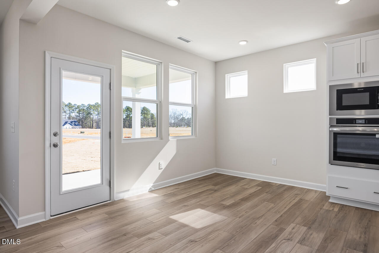 233 Tenure Lane Lillington, NC 27546 - Photo 8 of 30 a view of empty room with wooden floor and fan