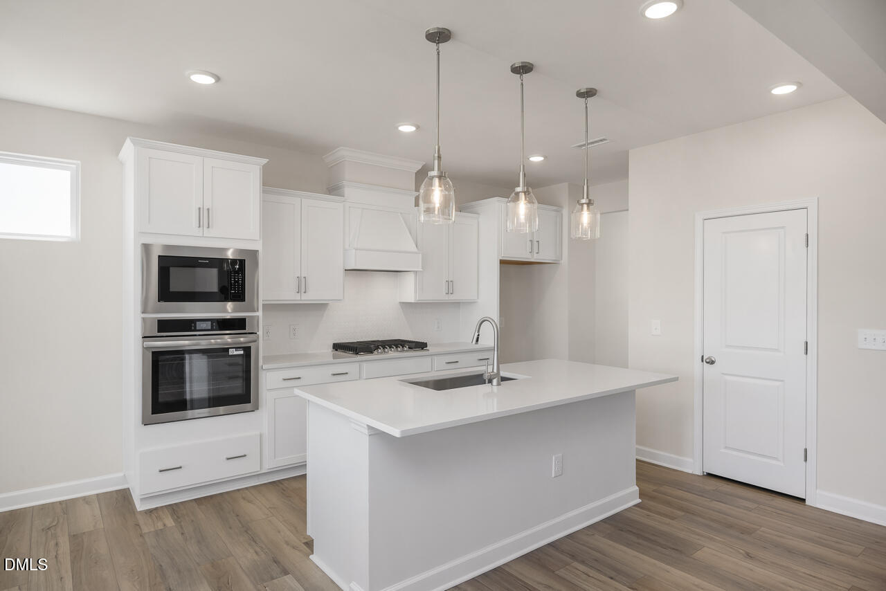 233 Tenure Lane Lillington, NC 27546 - Photo 9 of 30 a kitchen with a sink a microwave a stove and refrigerator