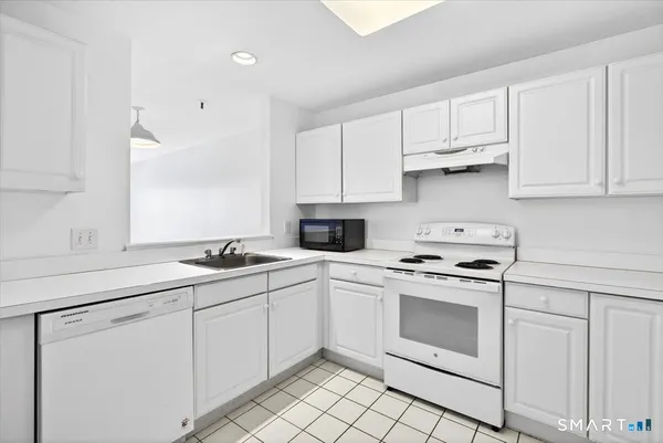 a kitchen with white cabinets stainless steel appliances and sink