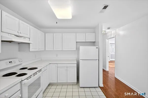 a kitchen with a white cabinets and white appliances