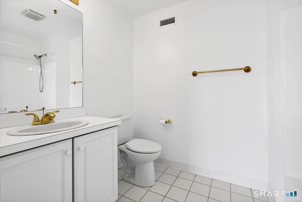 a bathroom with a granite countertop sink a toilet and a mirror
