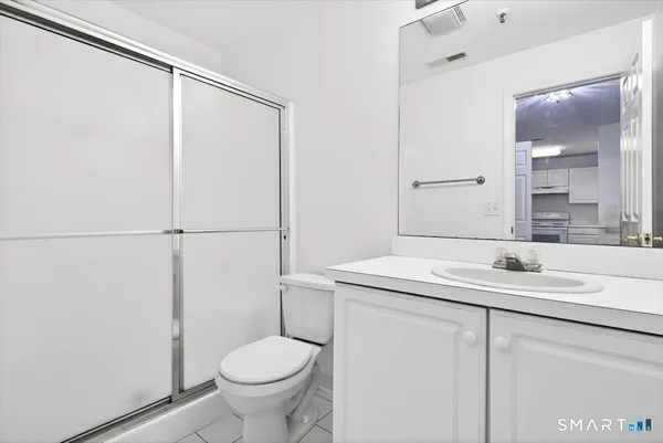 a bathroom with a granite countertop sink toilet and shower
