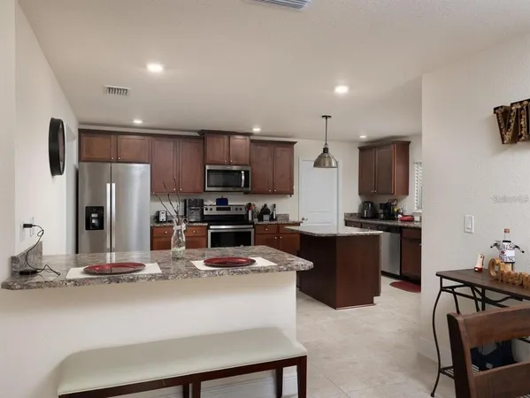 a kitchen with kitchen island a sink stove and refrigerator
