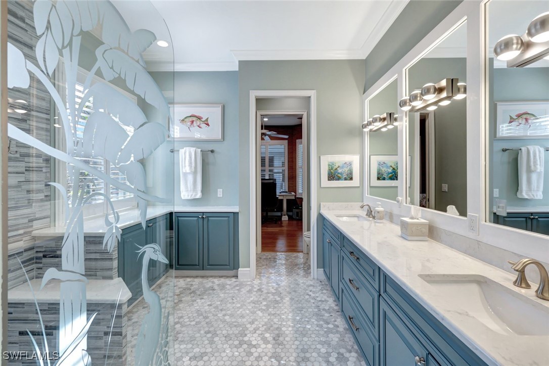 2450 Wulfert Road Sanibel, FL 33957 - Photo 27 of 44 a bathroom with double vanity sinks a large mirror and a shower
