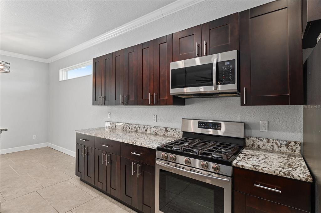 4765 Southeast 25th Street Ocala, FL 34480 - Photo 20 of 65 a kitchen with stainless steel appliances a stove a microwave sink and cabinets